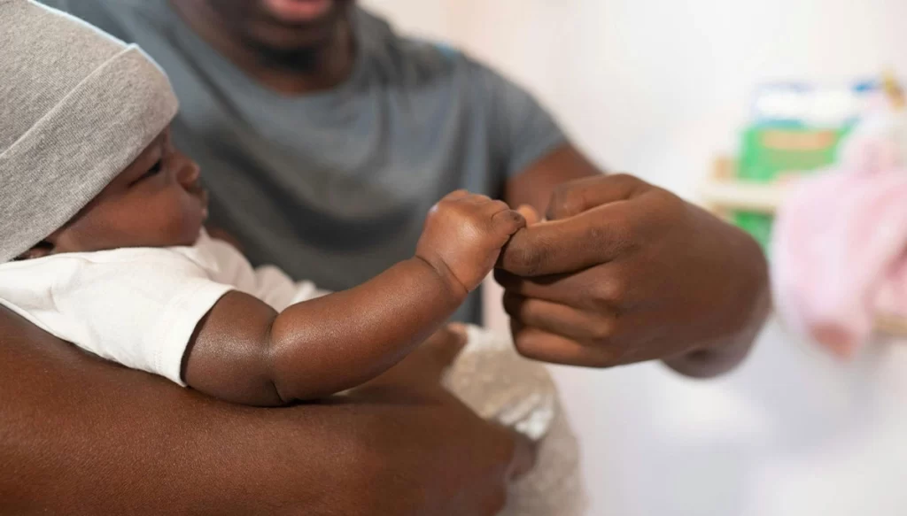 father holding baby's hand